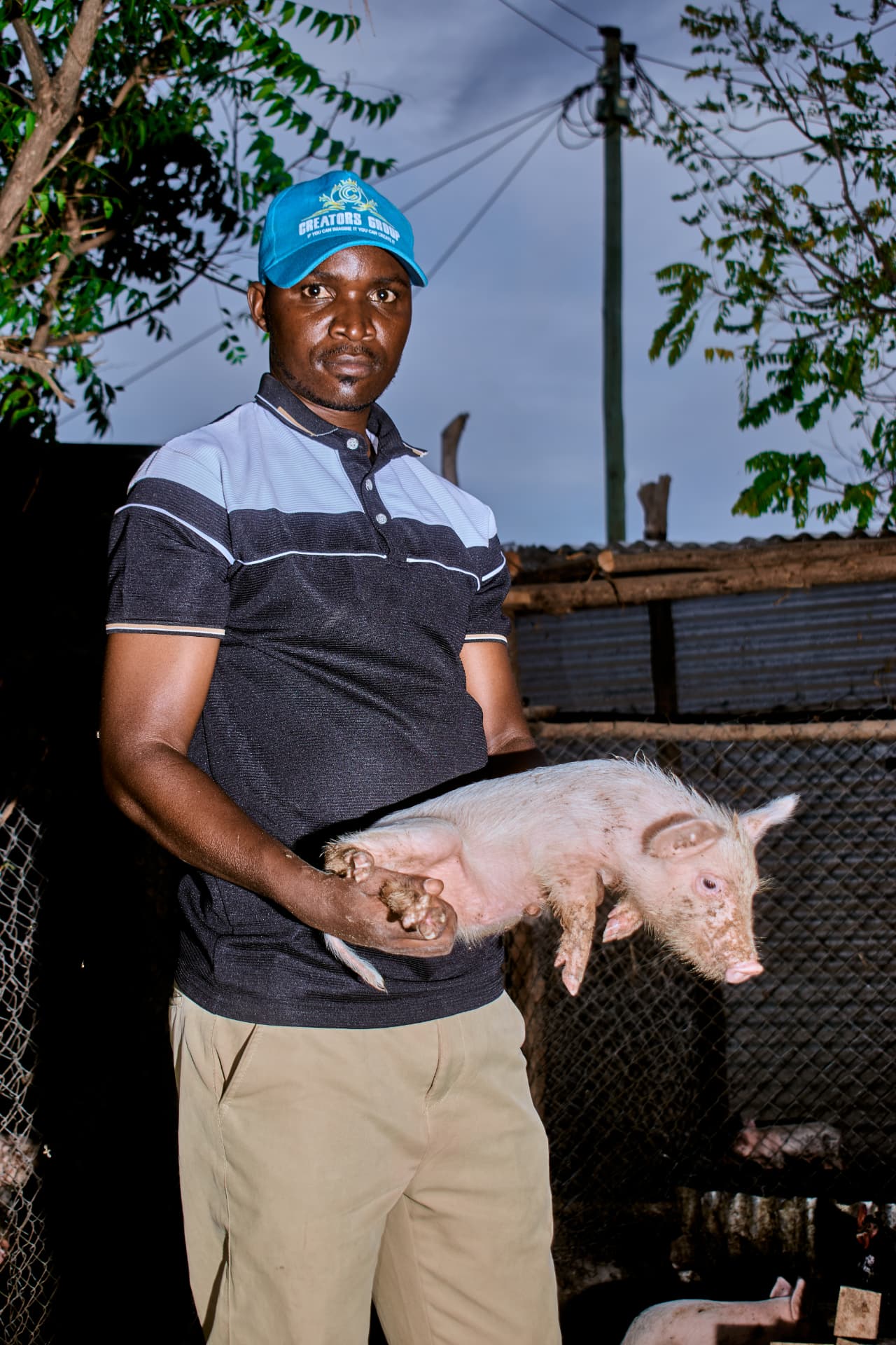 Portrait of Celestin holding a piglet